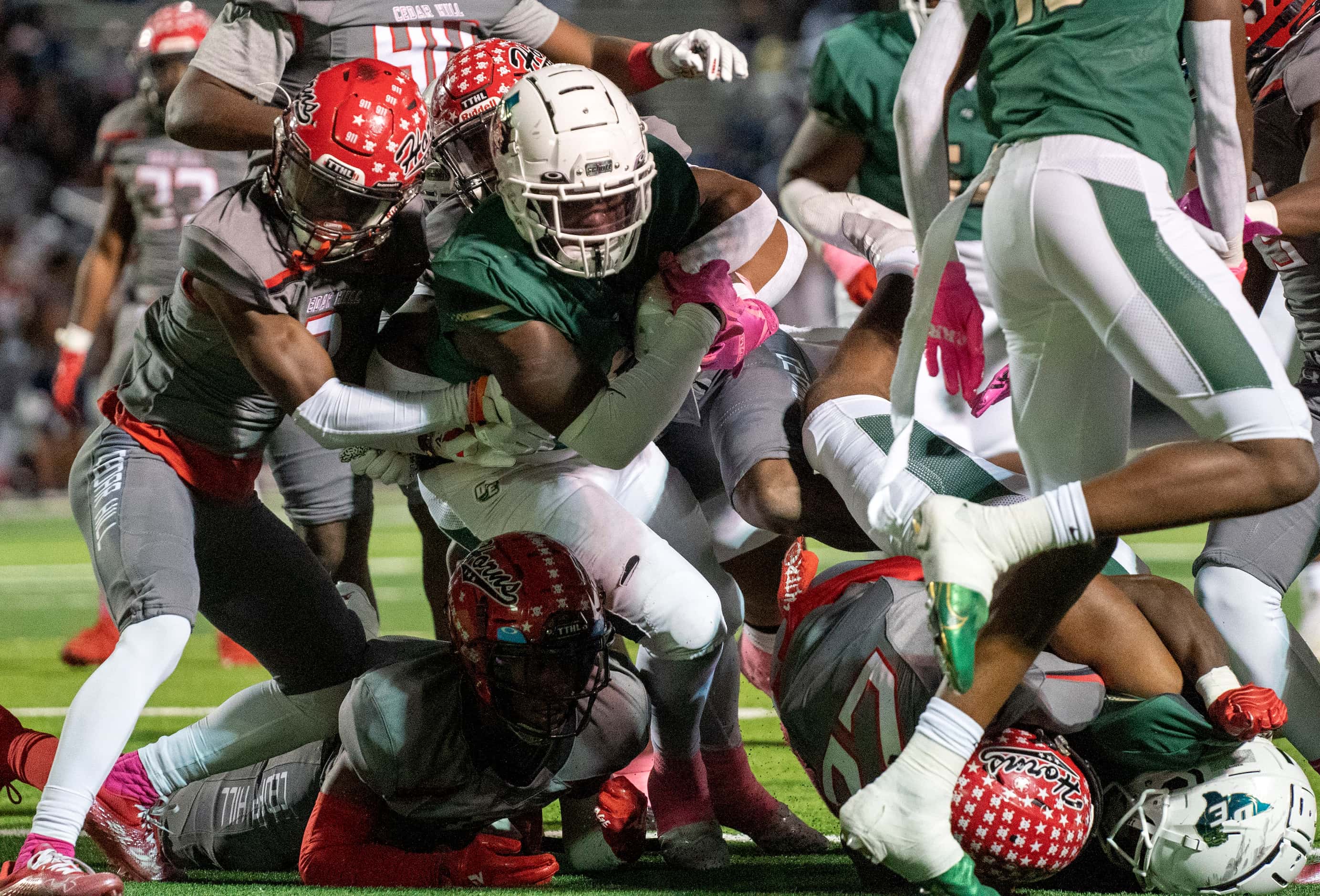 DeSoto senior running back Christopher Henley II (5) fights through the tackle of Cedar Hill...