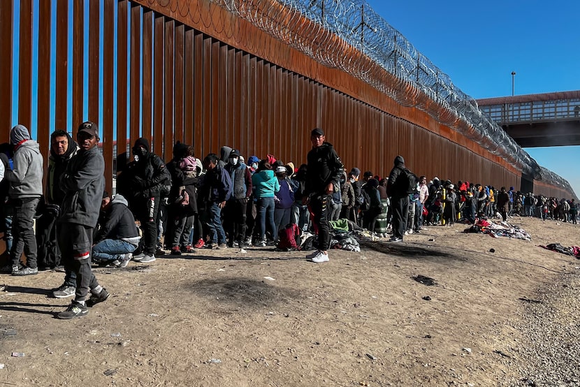 Migrants stood in line at a U.S.-Mexico border gate from the banks of the Rio Grande river...