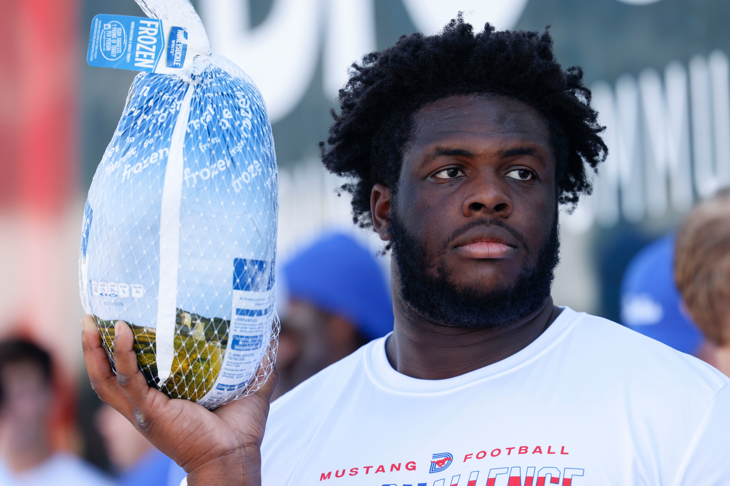 Southern Methodist University’s Anthony Booker Jr. waits to hand out a whole turkey, on...