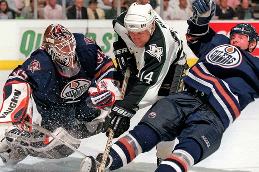  April 21, 1999-- Dallas Stars Dave Reid slices between Edmonton Oilers defender Alex...