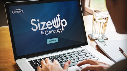 Closeup of an open laptop with the Comerica SizeUp logo displayed