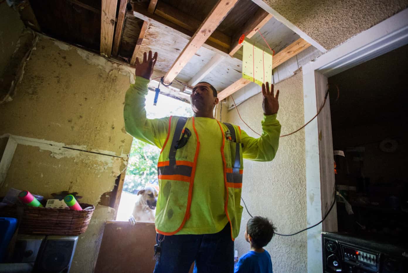 Abel Castro shows how his family's home looked before repairs on Monday. When his neighbors,...