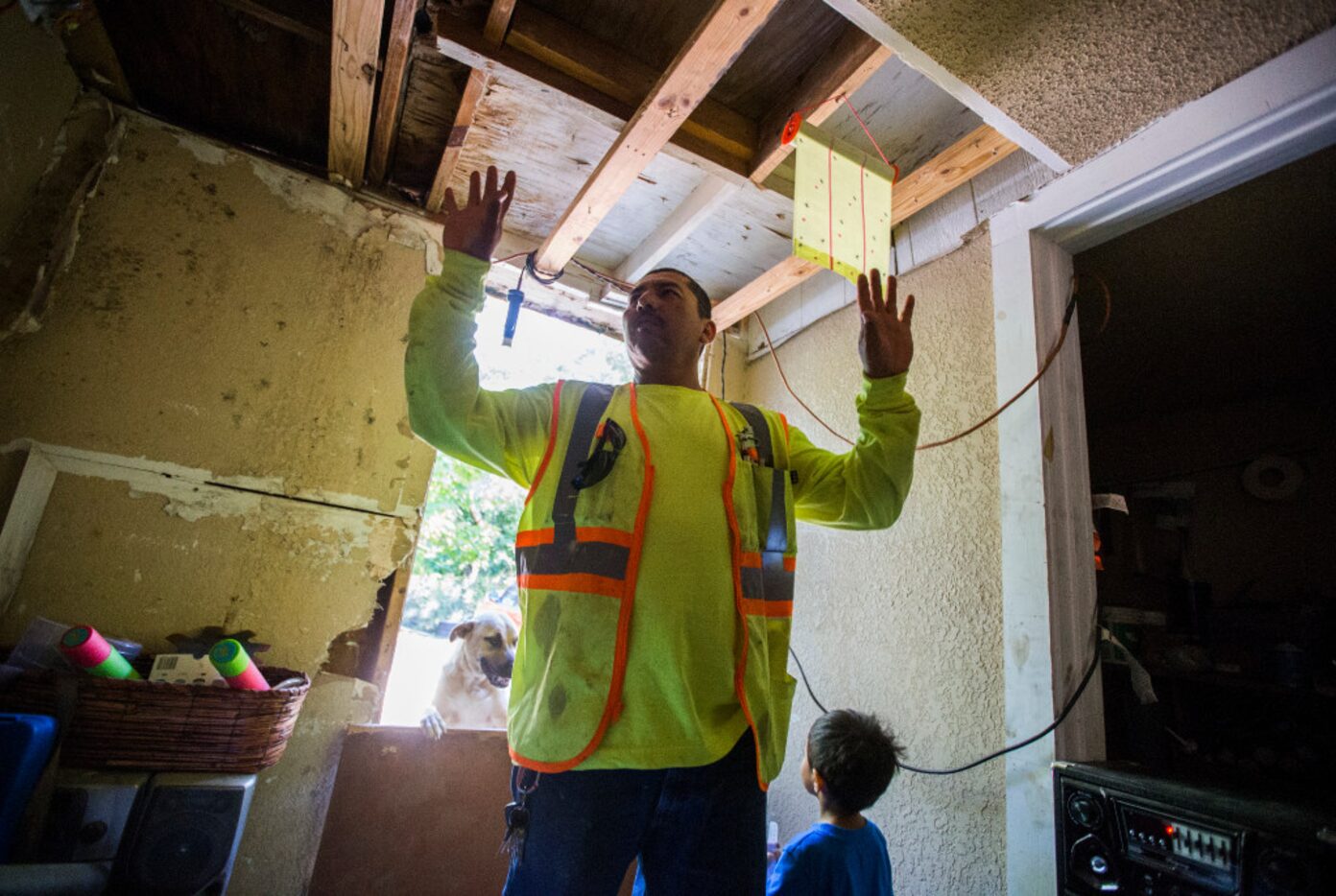 Abel Castro shows how his family's home looked before repairs on Monday. When his neighbors,...