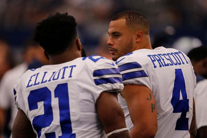 Dallas Cowboys Ezekiel Elliott and Dak Prescott talk on the sidelines during the game...