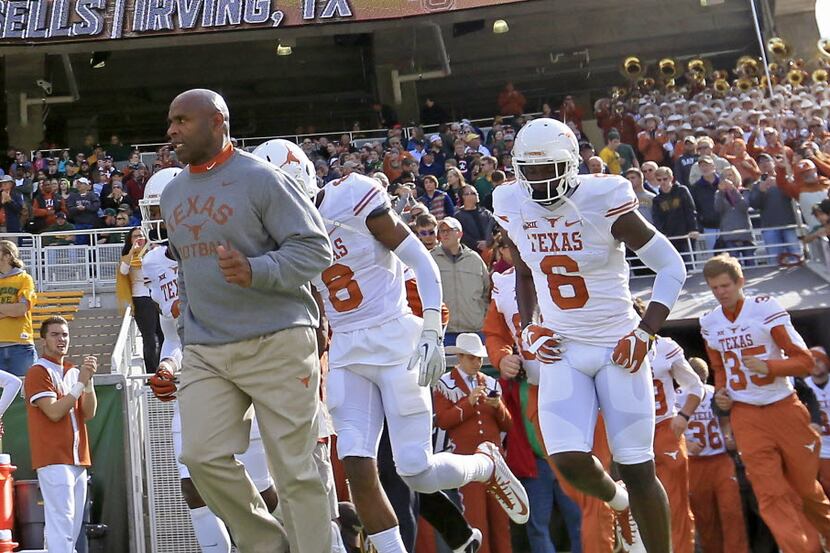 Texas head coach Charlie Strong, left, takes the field with his players against Baylor at...