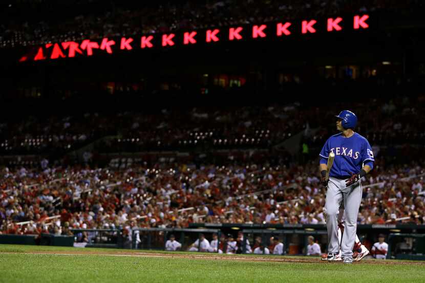 Texas Rangers' Nelson Cruz heads back to the dugout after striking out during the fourth...