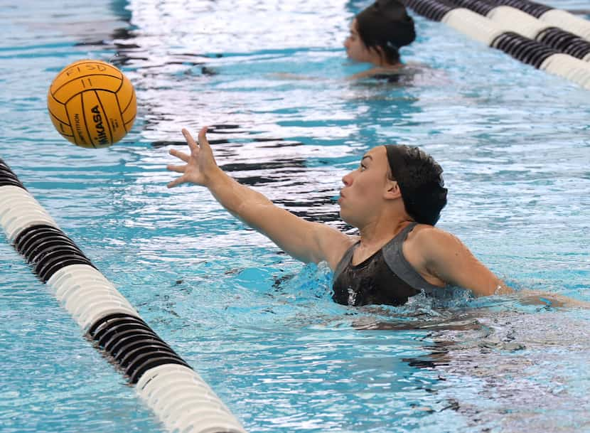 Forney High School freshman Izzy Romero reaches for a pass during team drills of the newly...