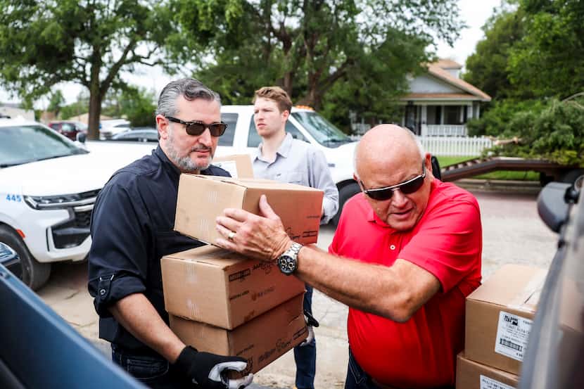 Mayor Kerry Symons of Perryton, Texas, hands boxes of donated food items to Sen. Ted Cruz,...