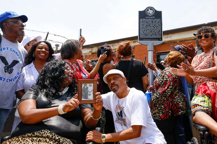 Candice Wicks (front left) of Oakcliff, holds a portrait of Jeff and Hanna Hill alongside...