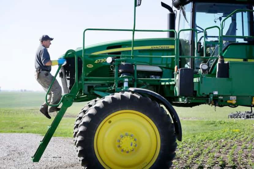 
Ray Gaesser climbs onto a sprayer on his farm near Corning, Iowa. Agriculture surged in...