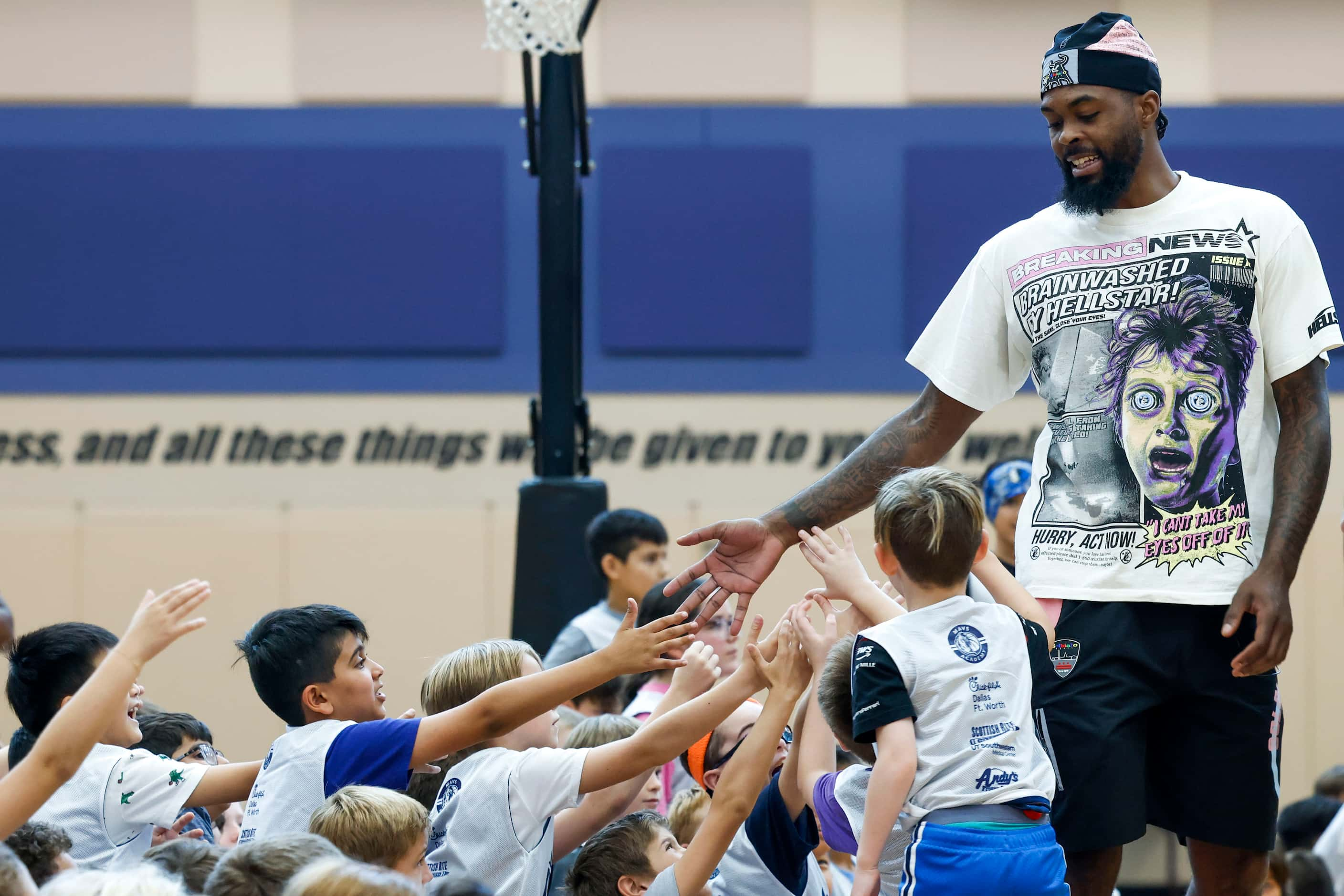 Dallas Mavericks’ Naji Marshall, hi-fives young basketball campers during a Hoop Camp,...