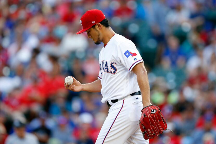 Texas Rangers starting pitcher Yu Darvish insects the ball after walking Miami Marlins...