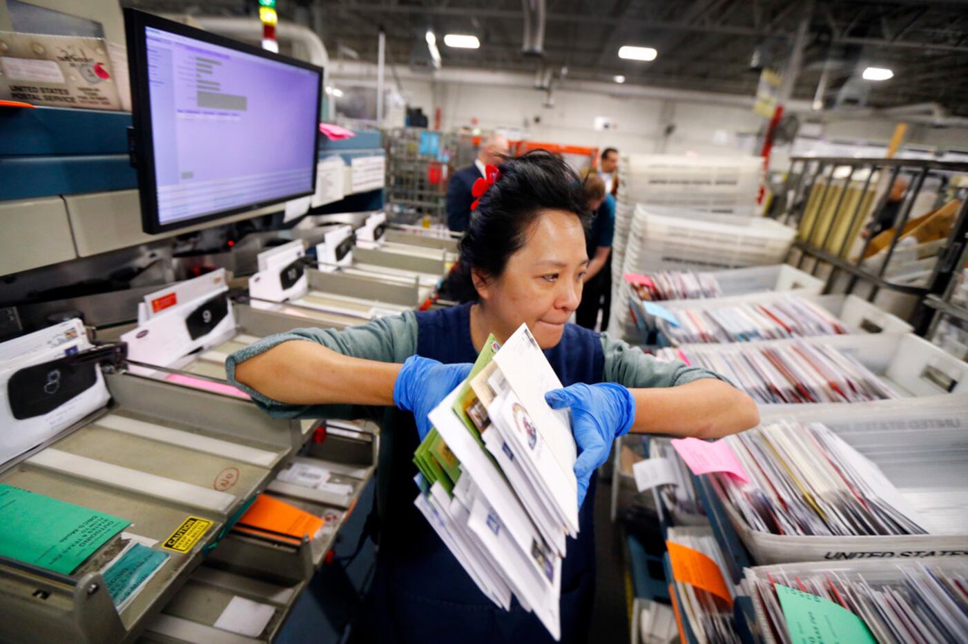 Clerk Petty Chow grabs some canceled mail items after they had been sorted in the Advanced...
