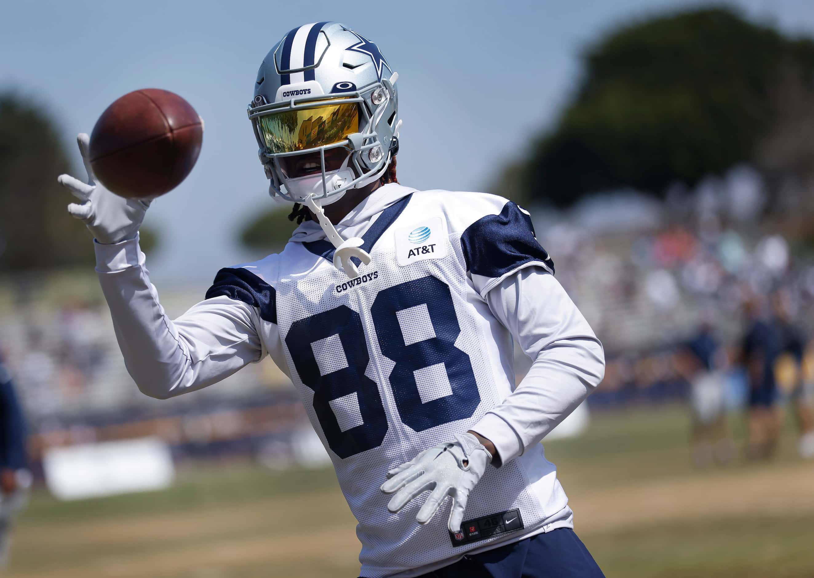 Dallas Cowboys wide receiver CeeDee Lamb (88) practices one-handed catches from a machine...