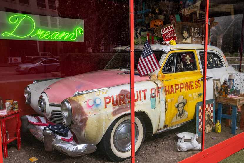 Carlos Ramirez's "Altar to a Dream" features a vintage car inside a red-framed glass box.