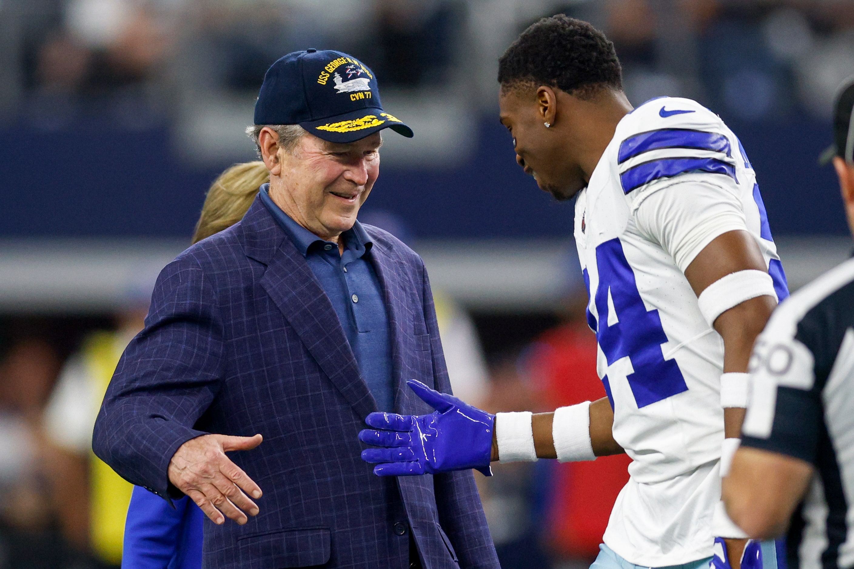 Former President George W. Bush shakes hands with Dallas Cowboys safety Israel Mukuamu after...