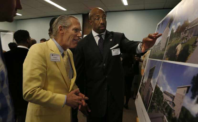 Trammell S. Crow (left)  and Paul Quinn President Michael J. Sorrell look over renderings...