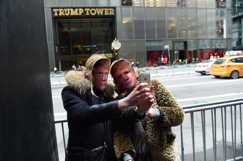 People wearing masks of US President Donald Trump take part in the 32nd Annual April Fools...