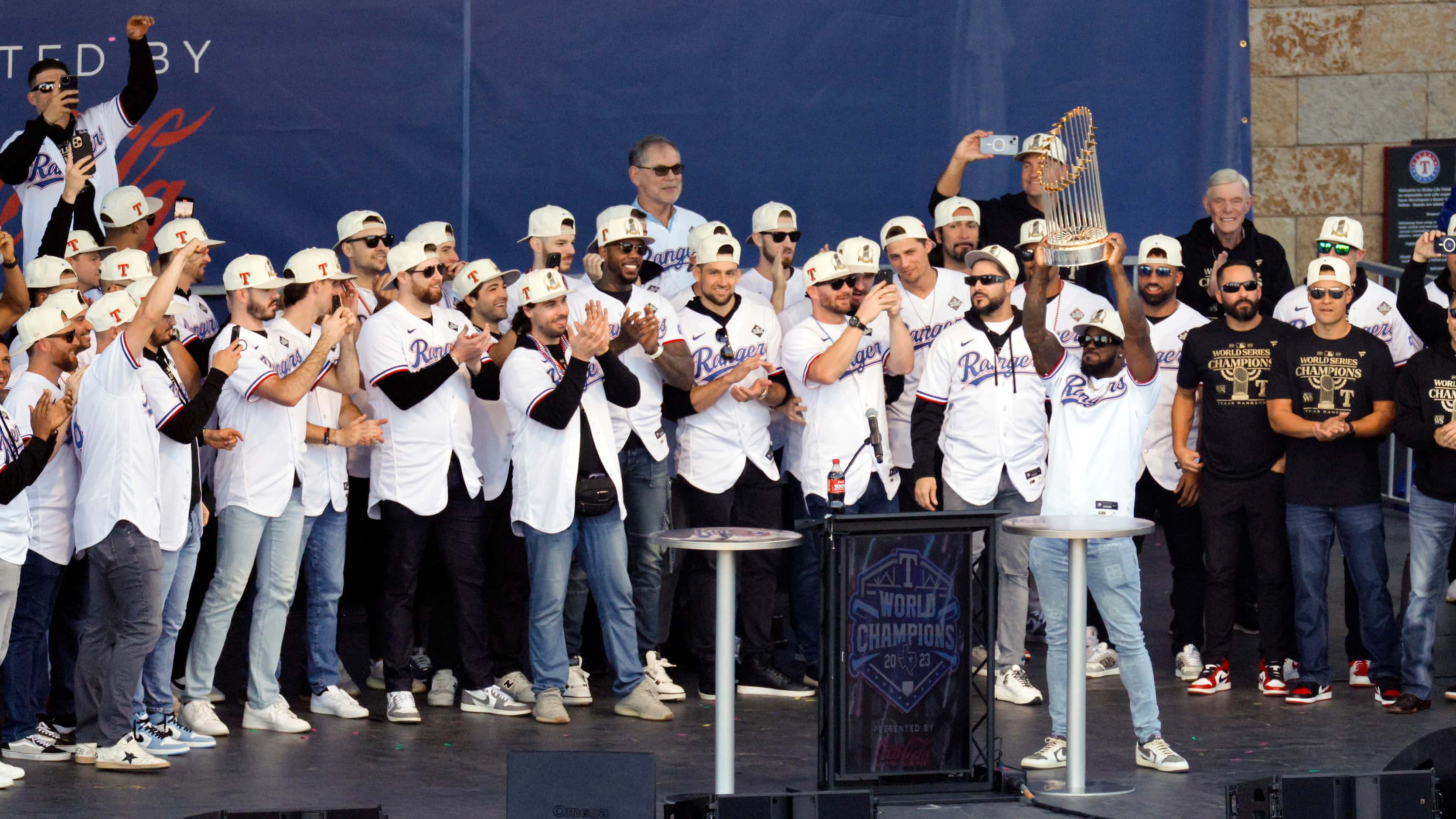 Texas Rangers right fielder Adolis Garcia raises the Commissioner’s Trophy during a ceremony...