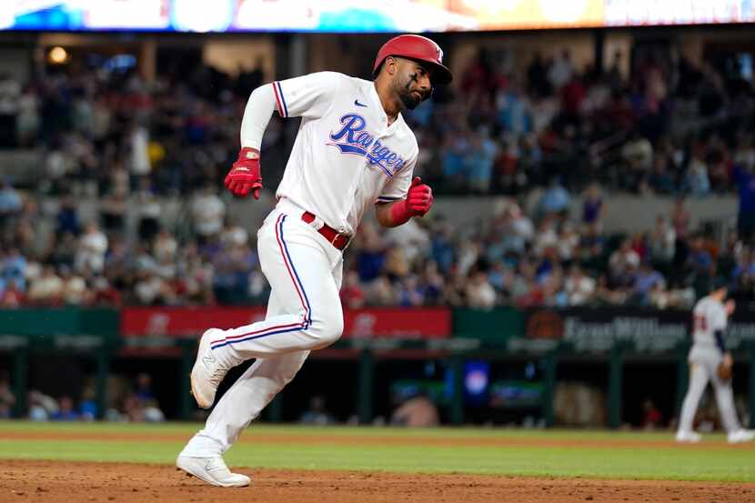 Texas Rangers' Ezequiel Duran rounds the bases after hittng a solo home run in the eighth...