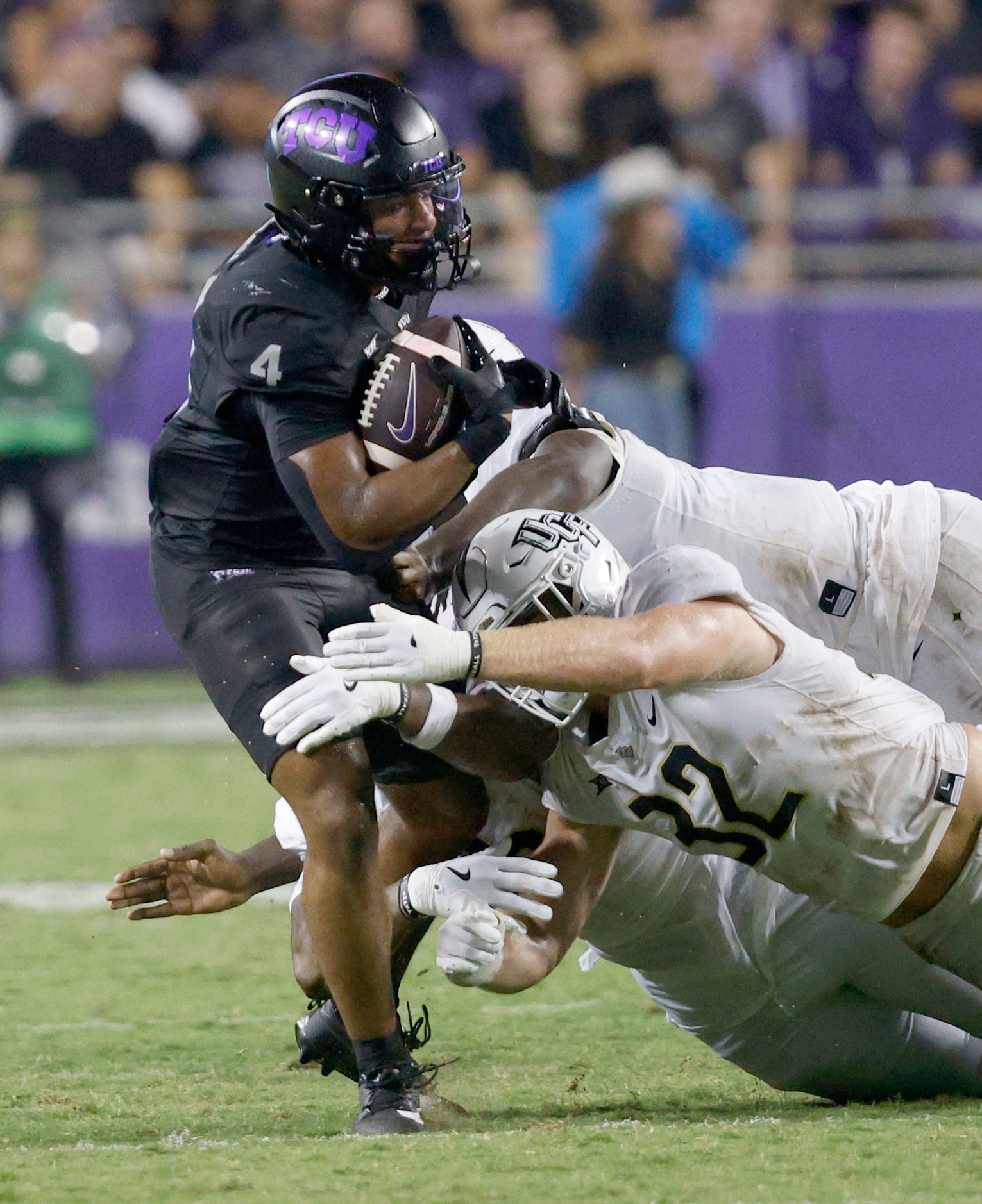 TCU running back Cam Cook (4) is tackled by UCF linebacker Ethan Barr (32) and UCF defensive...