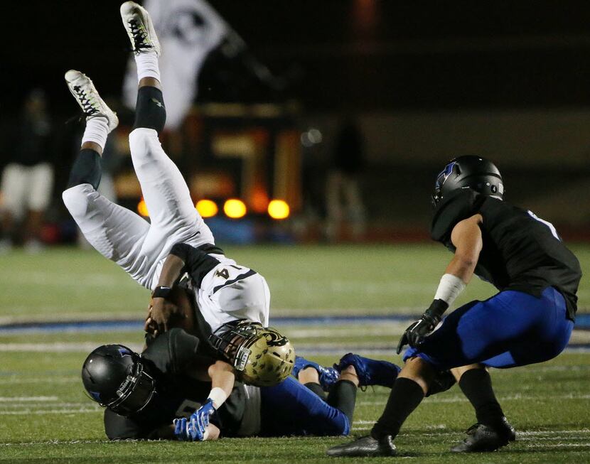 Plano East wide receiver Cameron Moore (14) is tackled by Hebron defensive back Colton...