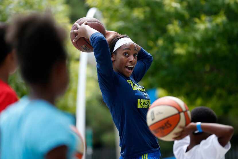 Dallas Wings forward Glory Johnson demonstrates passing the basketball to young kids....