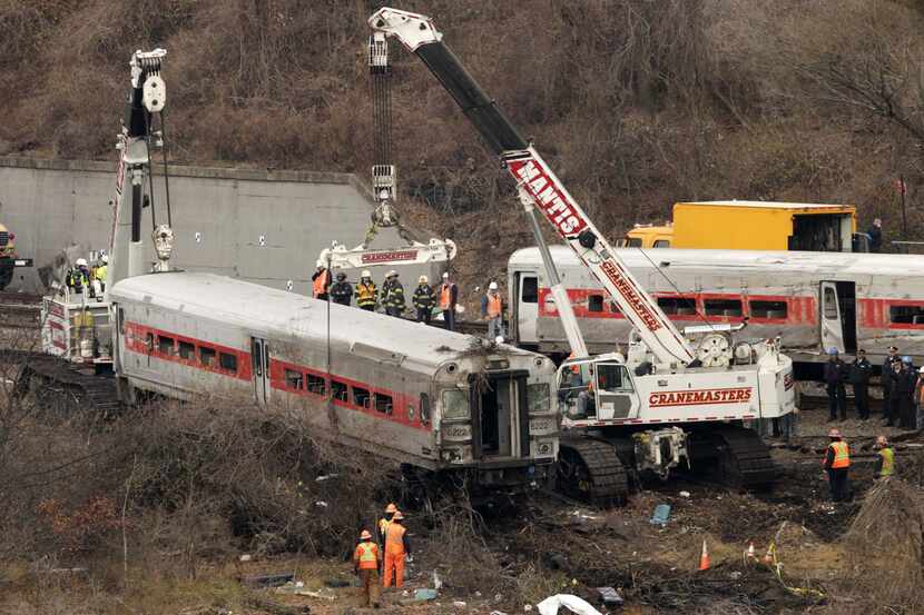 Cranes salvage the last car from from a train derailment in the Bronx section of New York,...