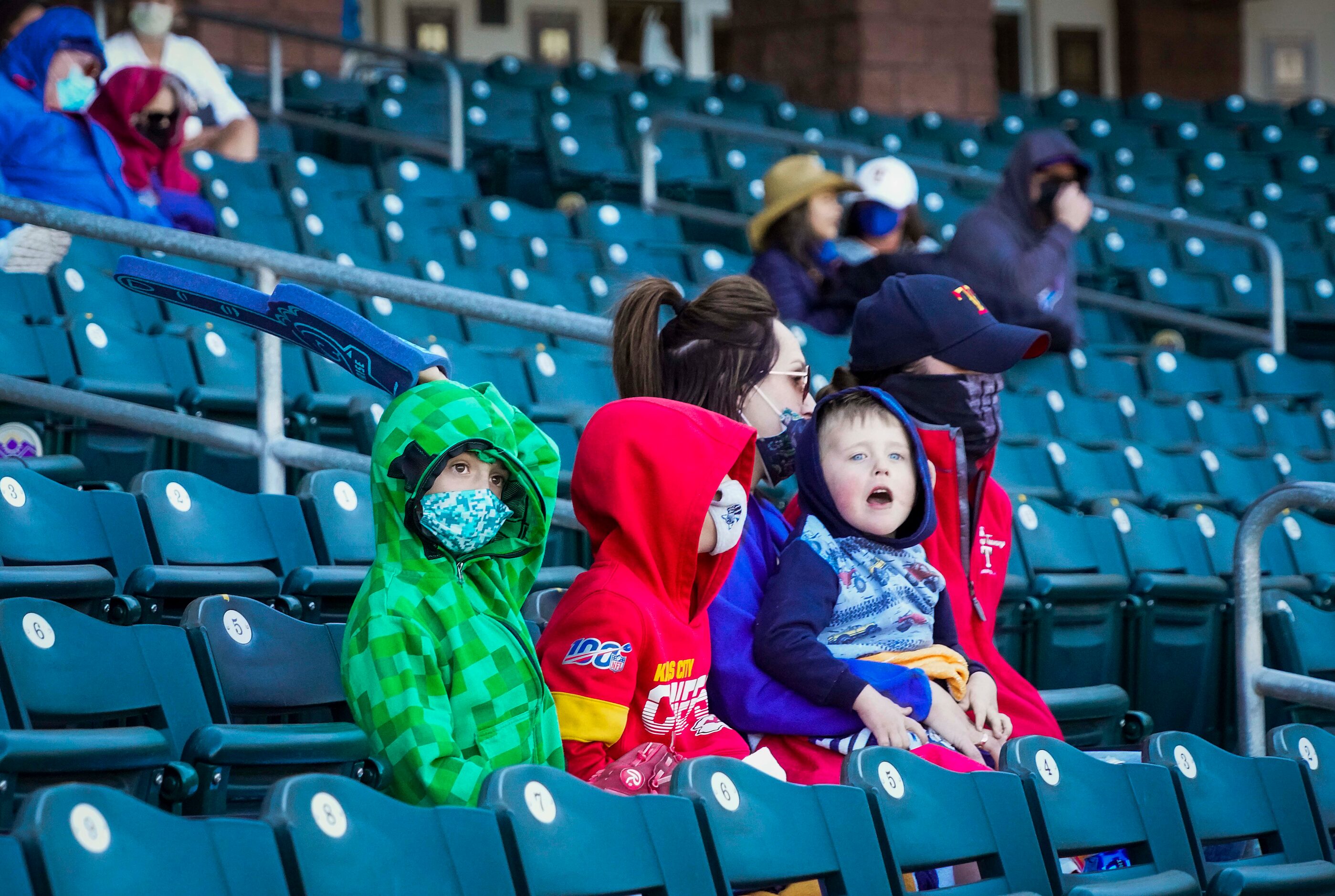 Fans bundle against a chilly afternoon as they watch from socially distant ‘pods’ during a...