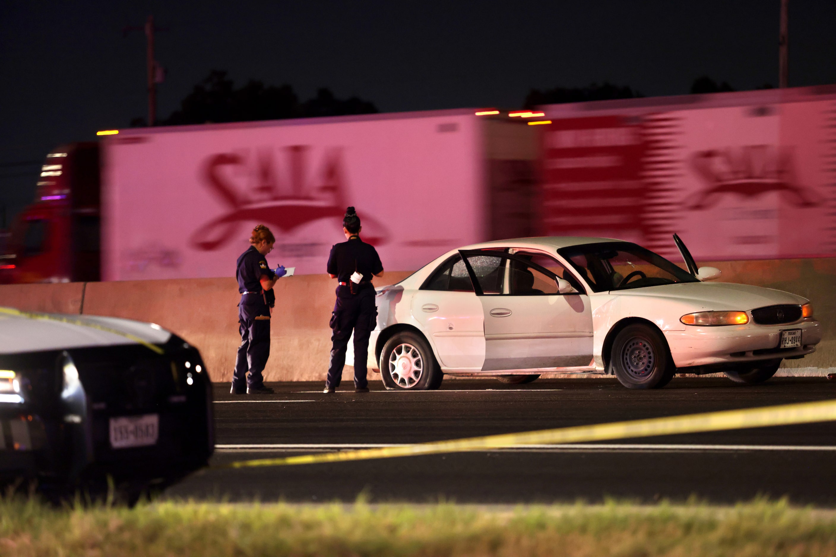 Officers examine a murder suspect's white Buick sedan for evidence in Lewisville, TX, on Aug...