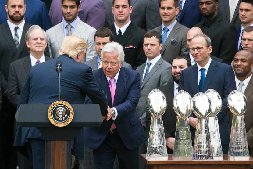 President Donald Trump shakes hands with Robert Kraft, the owner of the New England...
