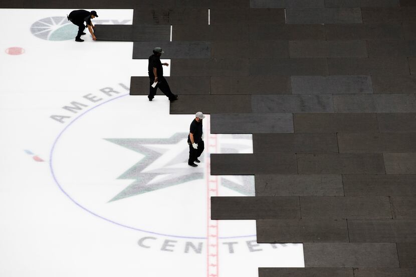 Crews cover the Dallas Stars ice after the NHL season was put on hold due to coronavirus on...