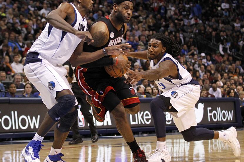 Miami Heat small forward LeBron James (6) drives between Dallas Mavericks center Bernard...