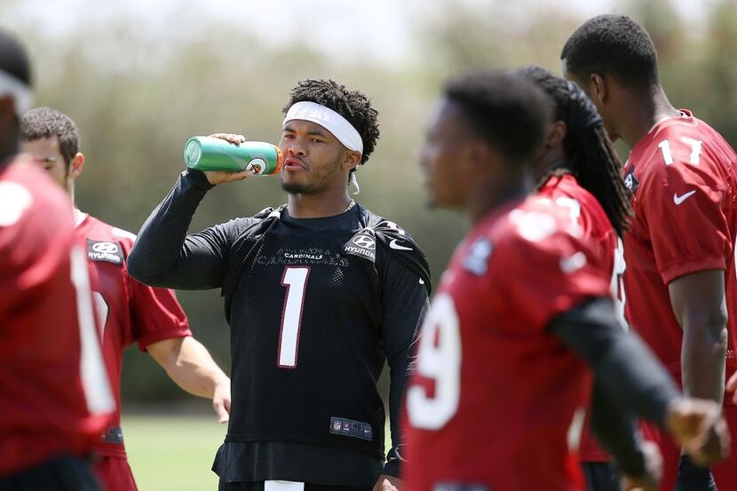 Arizona Cardinals rookie quarterback Kyler Murray takes a drink after stretching out prior...