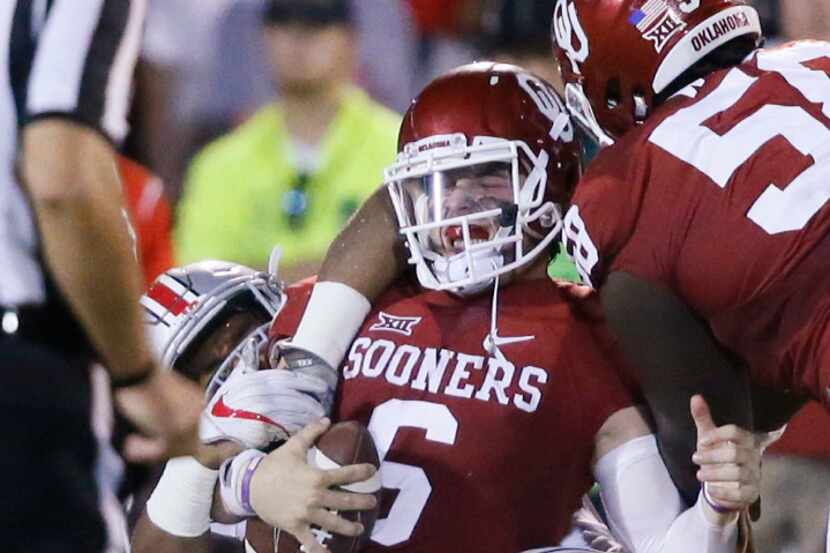 Oklahoma quarterback Baker Mayfield (6) is tackled by a number of Ohio State players during...