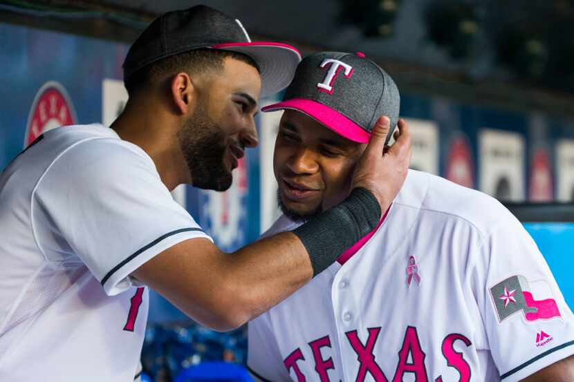 Texas Rangers right fielder Nomar Mazara (30) hugs shortstop Elvis Andrus (1) in the dugout...