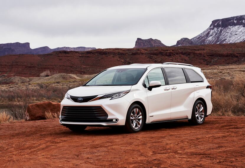 A white Toyota Sienna sits in front of a mountain range.