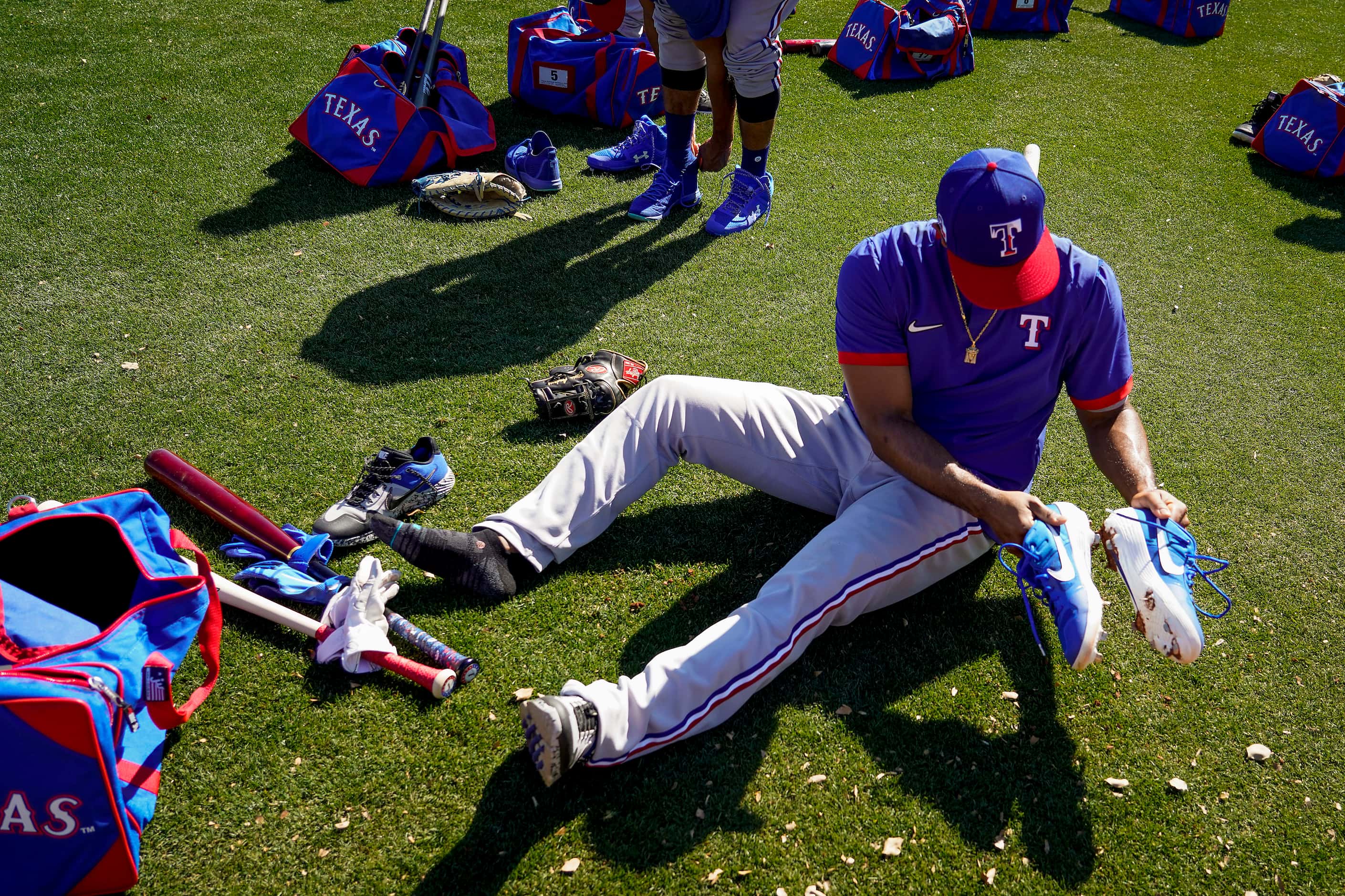 Texas Rangers shortstop Elvis Andrus knocks mud from his cleats during a spring training...
