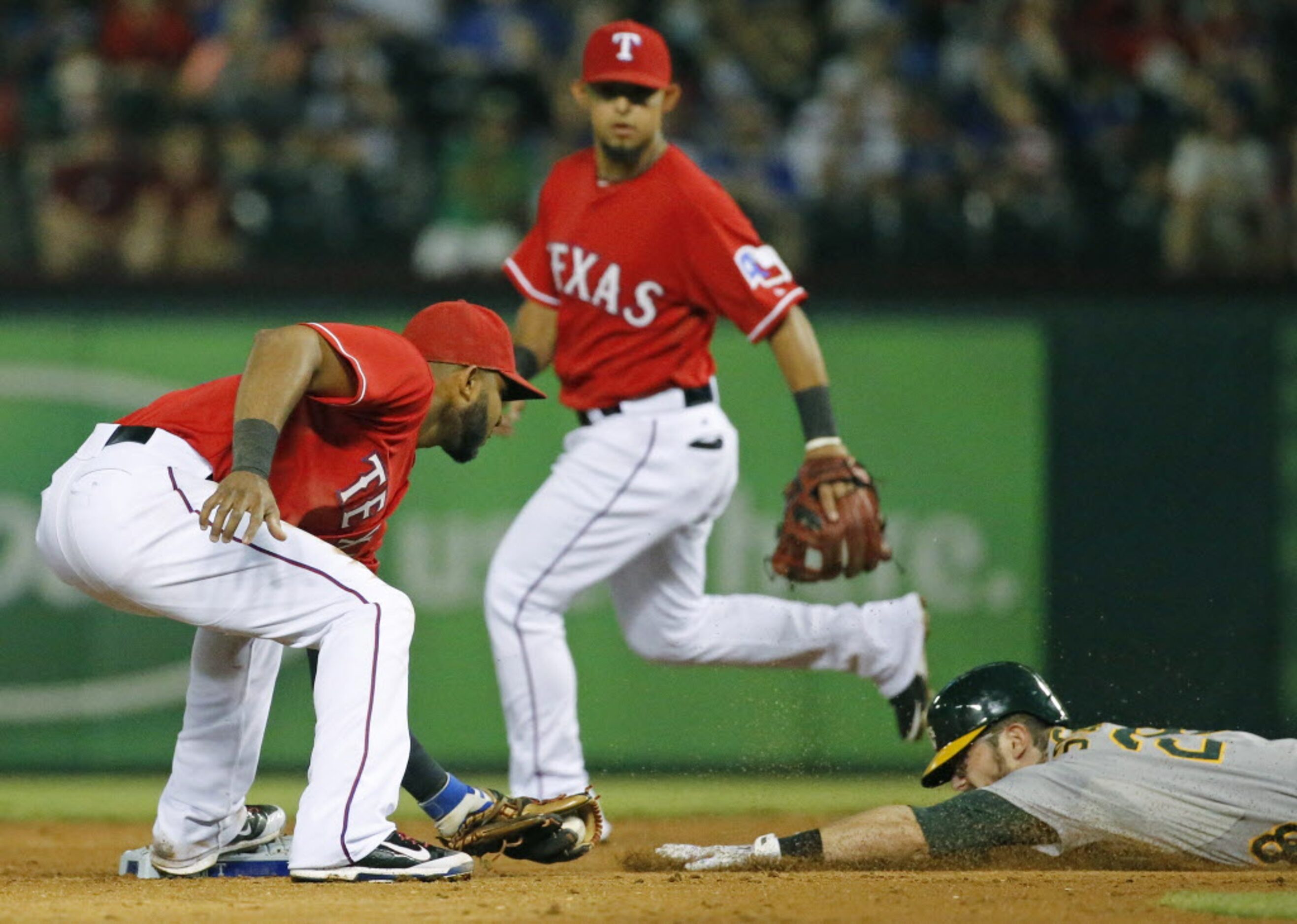 Texas shortstop Elvis Andrus tags out Oakland's Eric Sogard on an attempted steal of second...