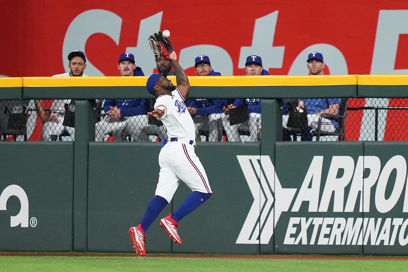 Texas Rangers center fielder Adolis Garcia makes a catch at the wall on a ball hit by...