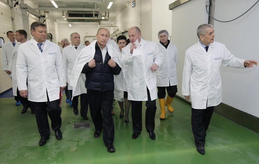 Yevgeny Prigozhin (center right) with President Vladimir Putin at his school lunches factory...