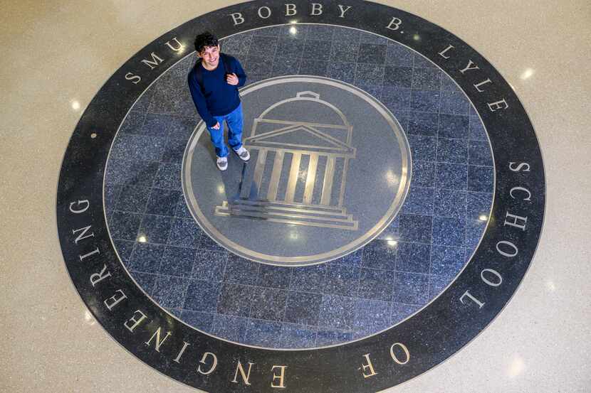 SMU student stands on a large decorative tiled seal that says "SMU Bobby B. Lyle School of...
