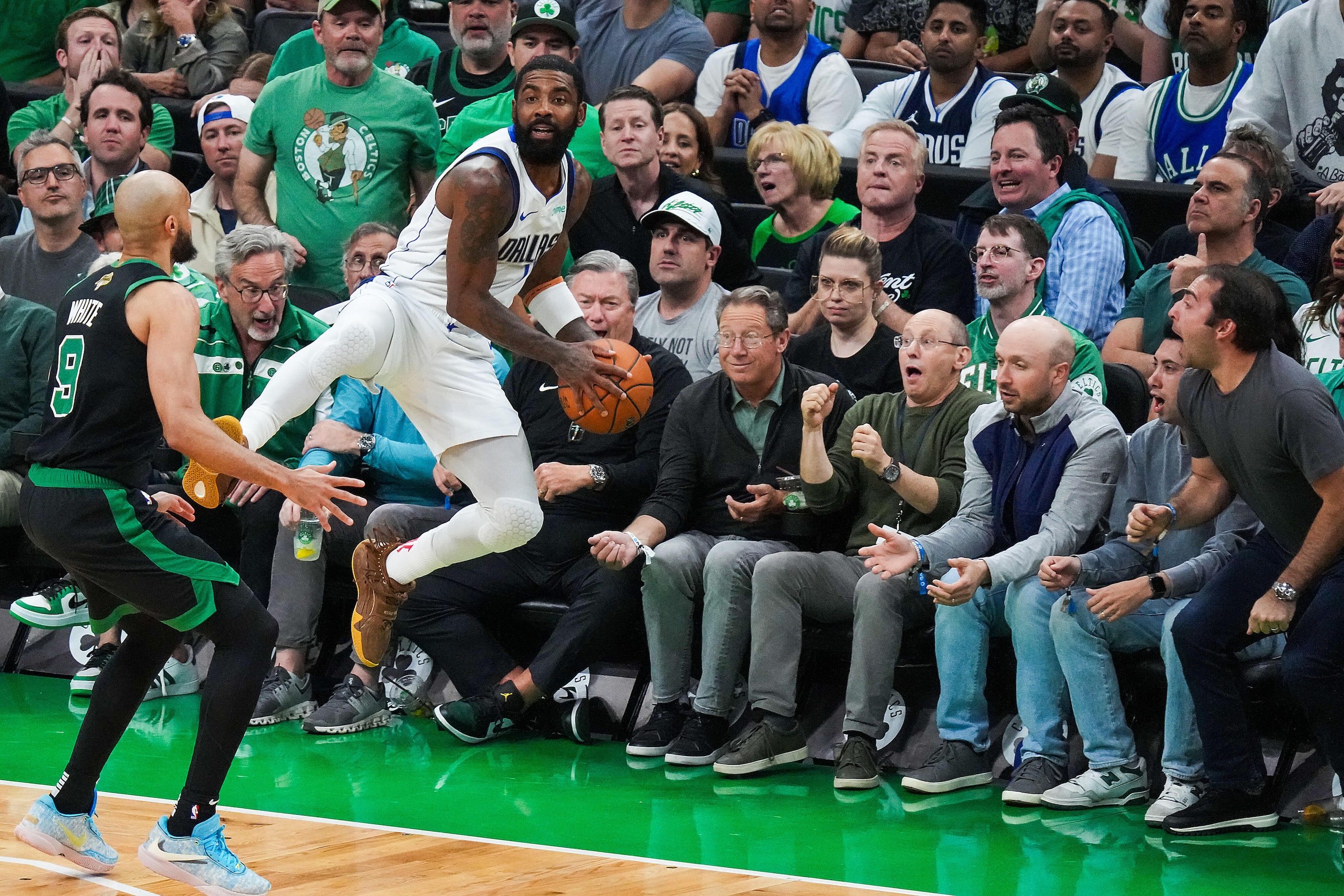 Dallas Mavericks guard Kyrie Irving (11) saves a ball from going out of bounds as Boston...