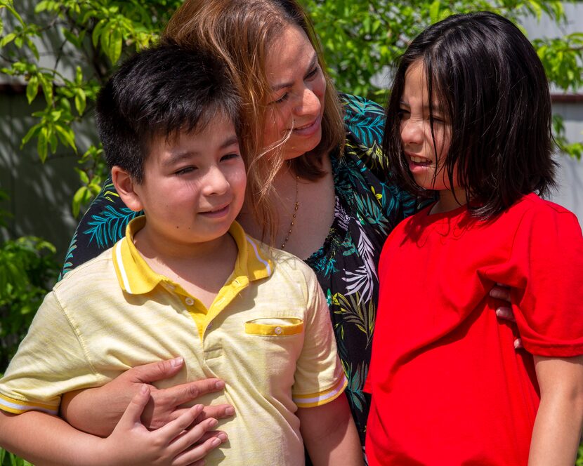 Maria Tobias (center) poses for a portrait wither her 8-year-old twins, Javier (left) and...