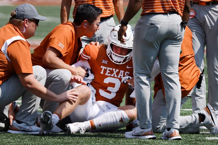 Texas Longhorns quarterback Quinn Ewers (3) is tended to after he took a hard hit from the...