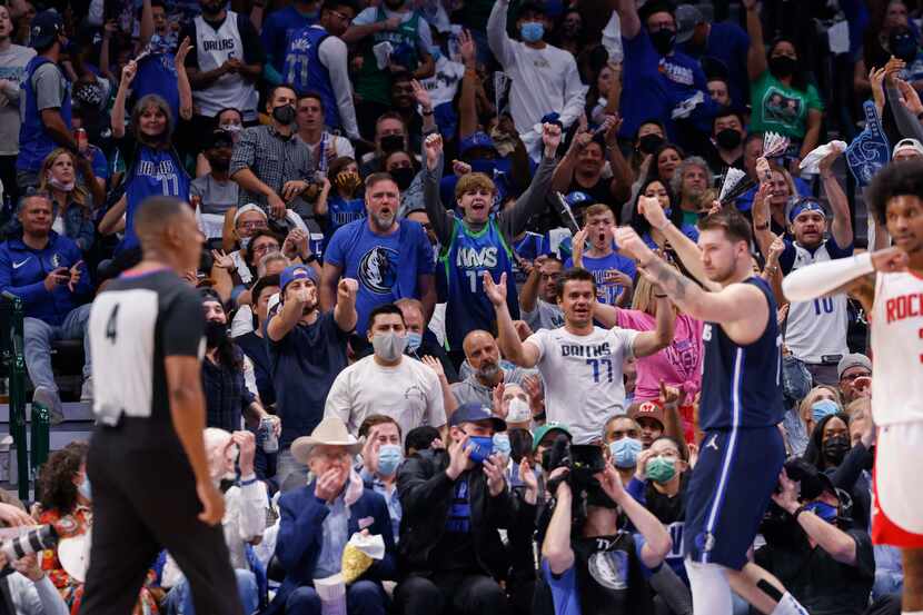 Seguidores de los Mavericks de Dallas celebran un enceste de Luka Doncic (der) durante un...