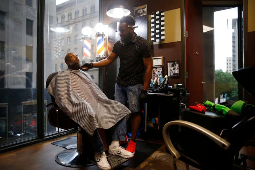 Carlos Gray, owner of Wow! "If Looks Could Kill" Hair Studio in downtown Dallas, works on...