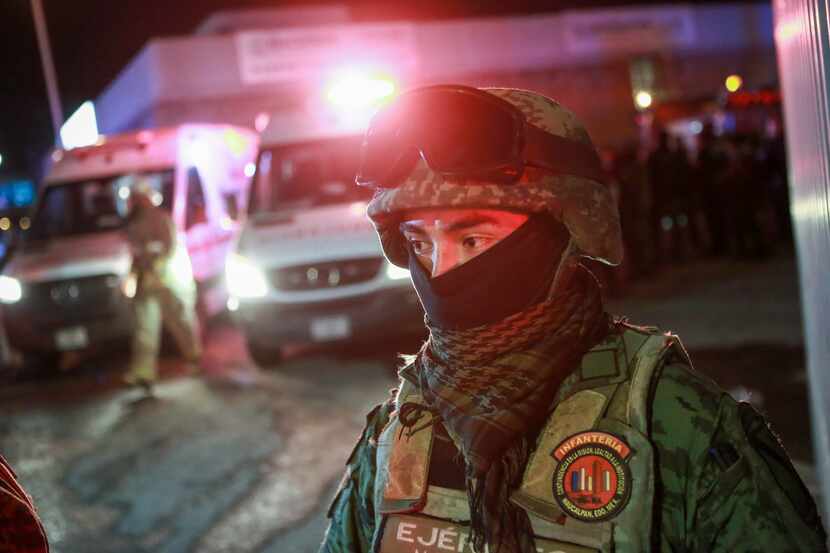 A soldier guards the entrance of an immigration detention center where a deadly fire broke...