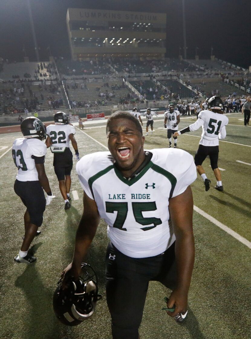 Lake Ridge Nose Tackle Terry Phillips celebrates with teammates after their their win...