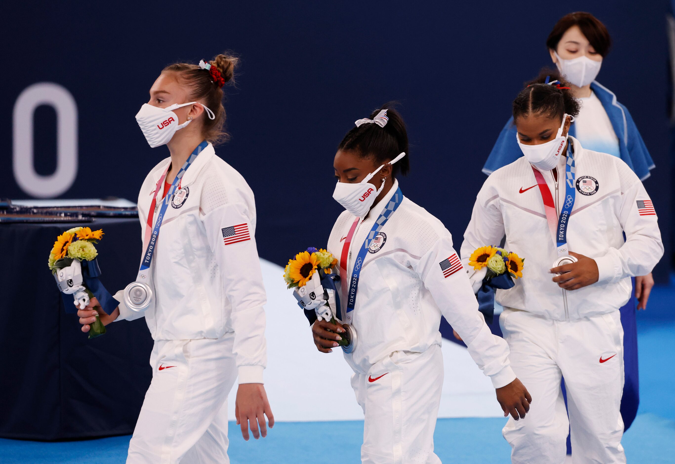 USA’s Grace McCallum, Simone Biles and Jordan Chiles make their way off the stage after...